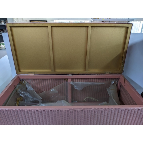 404 - A pink Lloyd Loom tub chair, along with a pink blanket chest with upholstered top raised on tapering... 