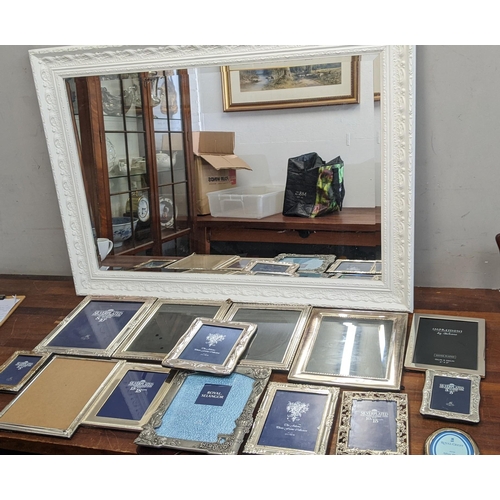 302 - A collection of silver plated photo frames, along with a mirror with an ornate white frame, 106cm x ... 