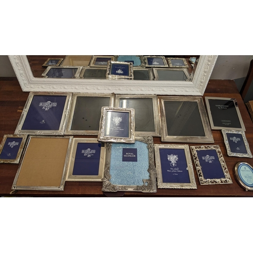 302 - A collection of silver plated photo frames, along with a mirror with an ornate white frame, 106cm x ... 