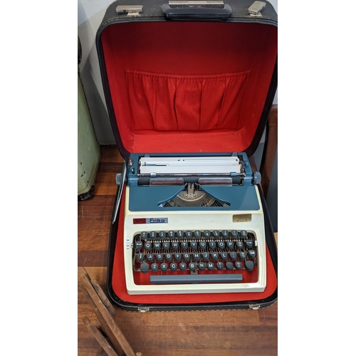 303 - A mixed lot to include a Daro Erika typewriter, a cased Eumig projector, a Ronco cordless portable s... 