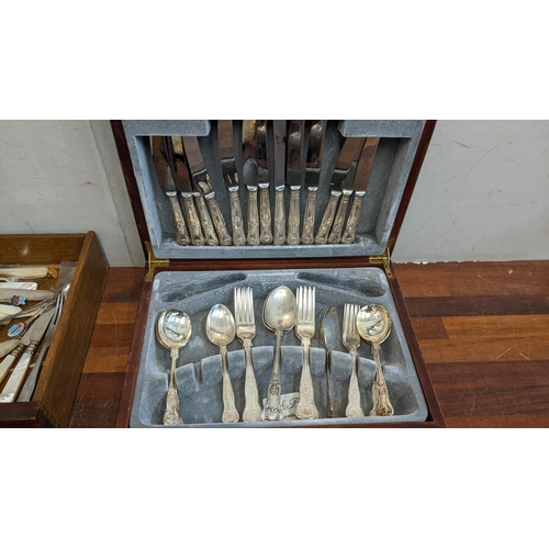 322 - A collection of silver plated items to include a boxed canteen of cutlery, mixed flatware, and souve... 