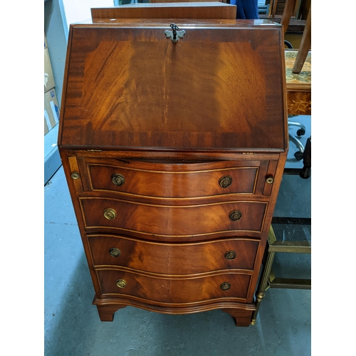 384 - A reproduction mahogany bureau of small proportions, drop flap revealing a pigeonhole and drawer int... 