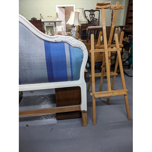 390 - Two wooden artists easels and a white painted wooden double bed headboard with upholstered panel and... 