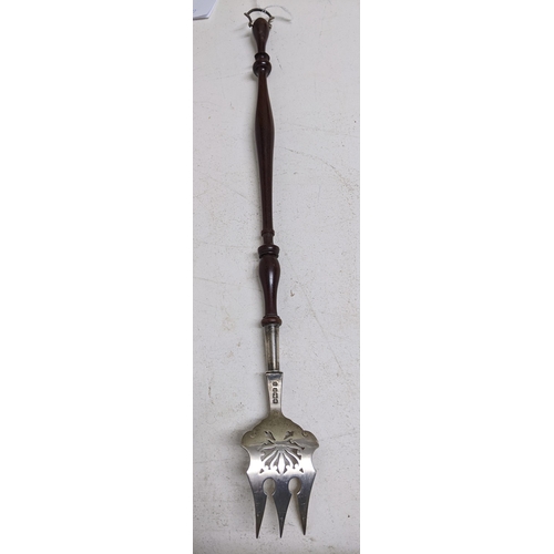 431 - An Edward VII silver and turned wood toasting fork, the handle terminating with a silver hanging loo... 