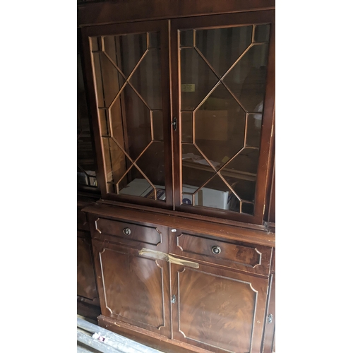 454 - A 20th century mahogany cabinet with a glazed and shelved top, over storage under a long drawers210c... 