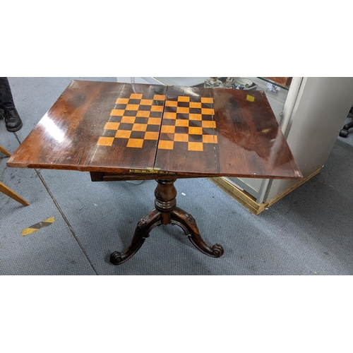 498 - An early Victorian rosewood fold over games table, the swivel top opening to reveal a games board, b... 