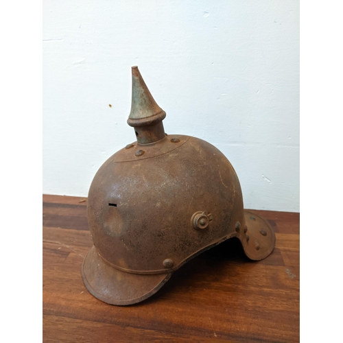 459 - A Prussian helmet stamped Junker 1915, with a leather interior, A/F and a World War II helmet, stamp... 