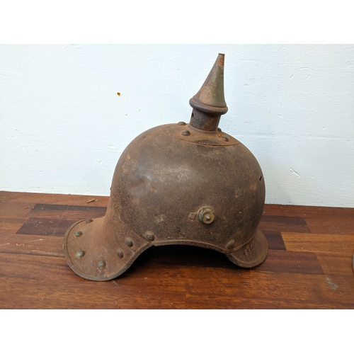 459 - A Prussian helmet stamped Junker 1915, with a leather interior, A/F and a World War II helmet, stamp... 