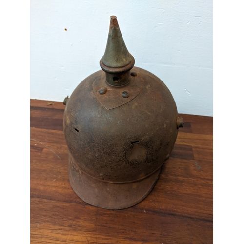 459 - A Prussian helmet stamped Junker 1915, with a leather interior, A/F and a World War II helmet, stamp... 