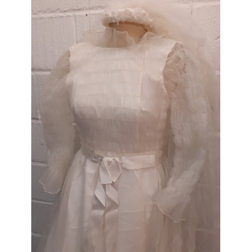 57 - Jean Varon, British Designer-A 1960's white wedding dress with ruffled collar and netted overgarment... 