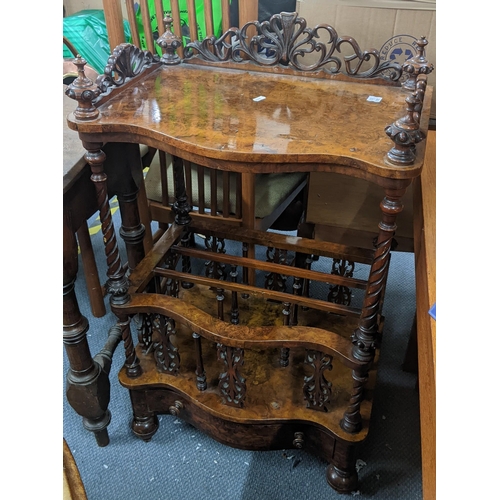 A Victorian walnut serpentine fronted Canterbury having a scroll cared