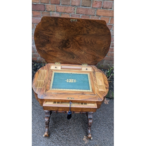 556 - A Victorian walnut work table having marquetry inlaid hinged top with a fitted interior and drawer b... 