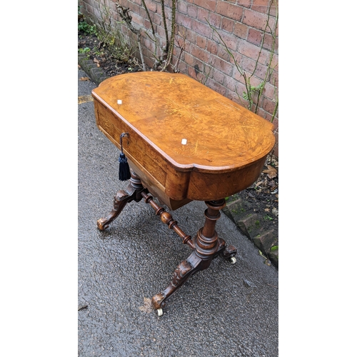 556 - A Victorian walnut work table having marquetry inlaid hinged top with a fitted interior and drawer b... 