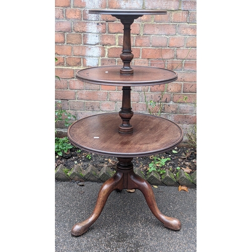 590 - A George III mahogany three tier dumb waiter having a turned column and on three cabriole legs, 113h... 