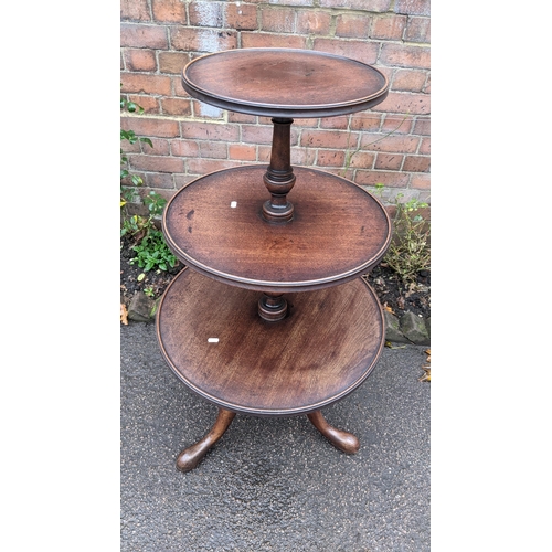 590 - A George III mahogany three tier dumb waiter having a turned column and on three cabriole legs, 113h... 