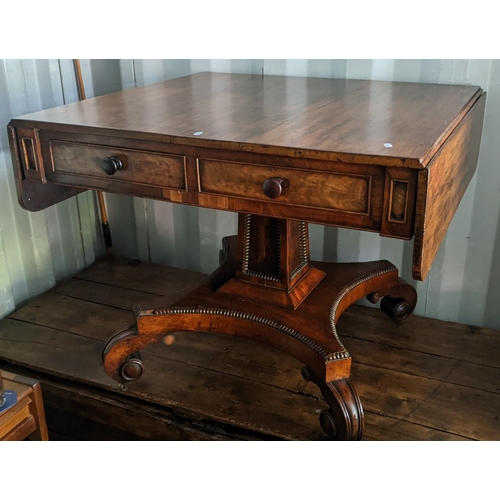 591 - A Regency mahogany sofa table having four drawers, square tapering column, quatrefoil base with scro... 