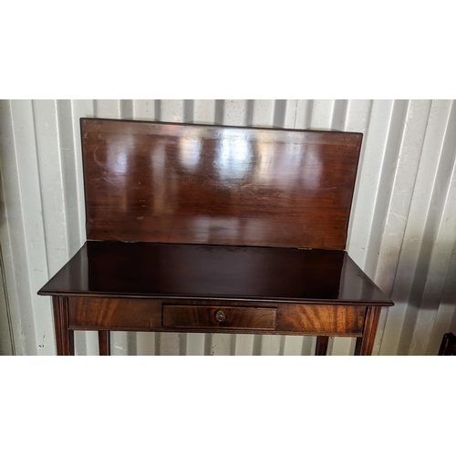 593 - A George III mahogany fold over tea table having a single drawer and tapering legs, 74h x 91w
Locati... 