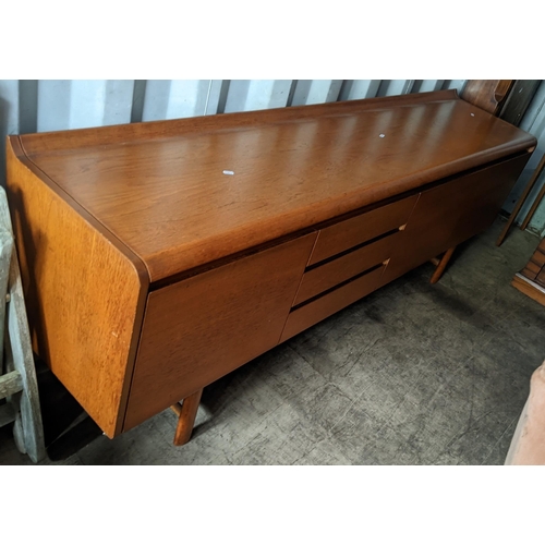 595 - A 1960s White & Newton 'Petersfield' teak sideboard with concave ledge back above an arrangement of ... 