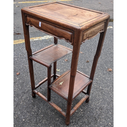 601 - A Chinese rosewood tea table having a rectangular top, two stepped lower tiers and turned legs, 73.5... 