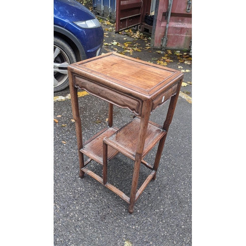 601 - A Chinese rosewood tea table having a rectangular top, two stepped lower tiers and turned legs, 73.5... 