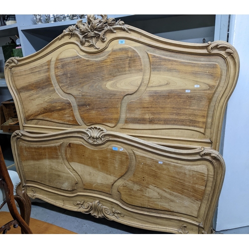 599 - An early 20th century French style carved walnut 5' bed frame comprising head and footboards and bed... 