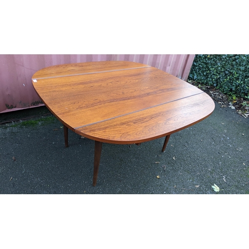 110 - A mid 20th century retro teak extending dining table together with six teak dining chairs, the table... 