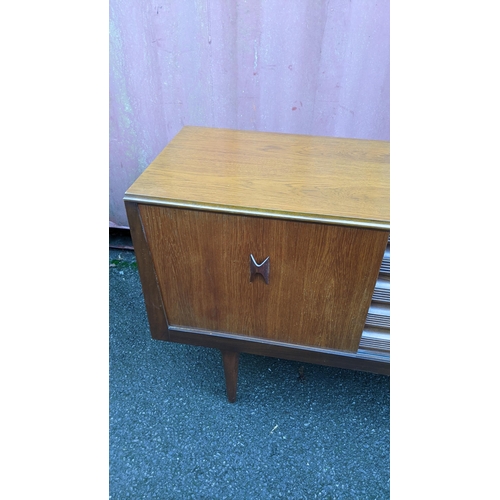 111 - A mid 20th century retro teak sideboard, circa 1960s, having four sliding cupboard doors opening to ... 