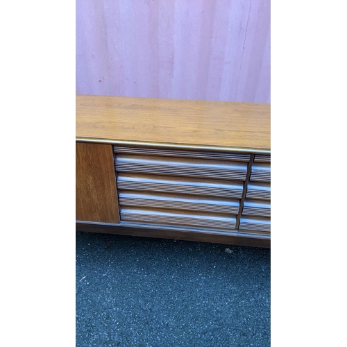 111 - A mid 20th century retro teak sideboard, circa 1960s, having four sliding cupboard doors opening to ... 