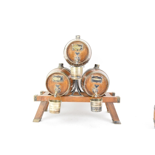 156 - An early 20th century oak and silver plated three barrel tabletop spirit dispenser stand and two tan... 