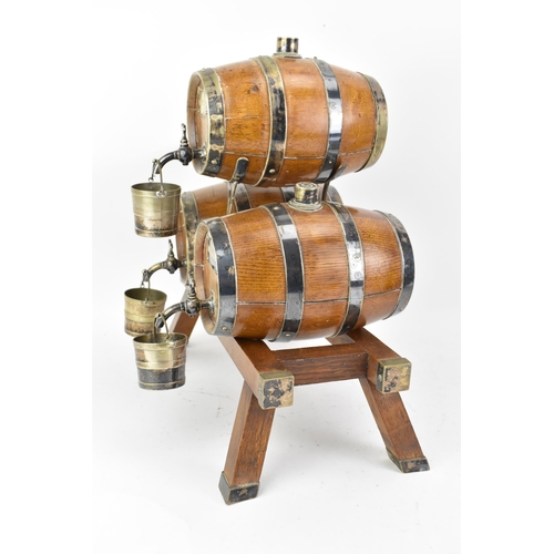 156 - An early 20th century oak and silver plated three barrel tabletop spirit dispenser stand and two tan... 