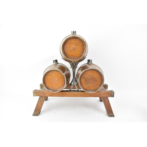 156 - An early 20th century oak and silver plated three barrel tabletop spirit dispenser stand and two tan... 