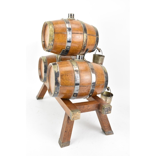 156 - An early 20th century oak and silver plated three barrel tabletop spirit dispenser stand and two tan... 