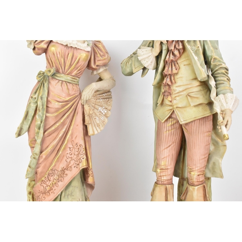 178 - A pair of early 20th century Royal Dux large figures, each in 18th century dress and raised on raise... 