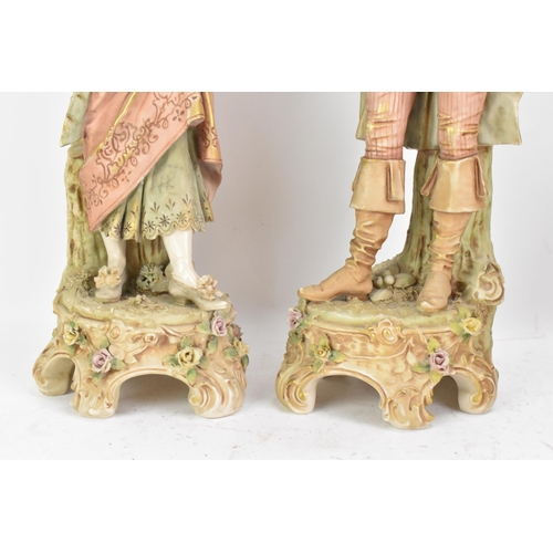 178 - A pair of early 20th century Royal Dux large figures, each in 18th century dress and raised on raise... 