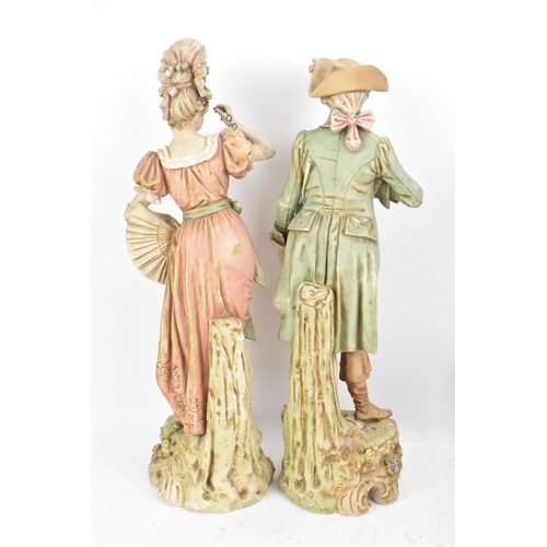 178 - A pair of early 20th century Royal Dux large figures, each in 18th century dress and raised on raise... 