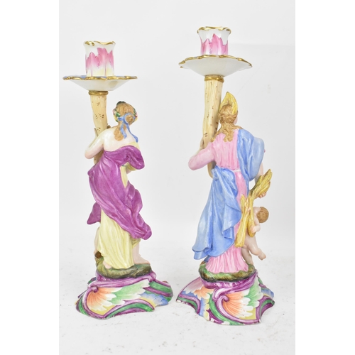 181 - Two 19th century Capodimonte porcelain figural candlesticks, each painted in polychrome enamels, eac... 