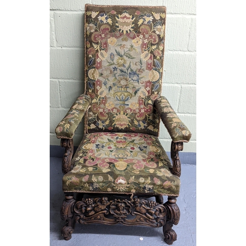 251 - An 18th/19th century walnut framed armchair, with tapestry floral upholstery, the heavily carved fra... 