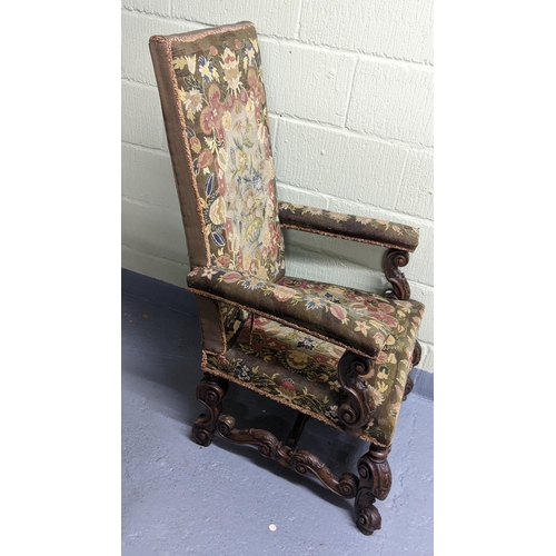 251 - An 18th/19th century walnut framed armchair, with tapestry floral upholstery, the heavily carved fra... 