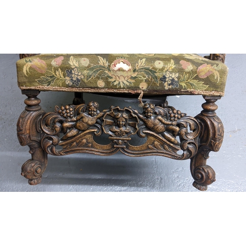 251 - An 18th/19th century walnut framed armchair, with tapestry floral upholstery, the heavily carved fra... 