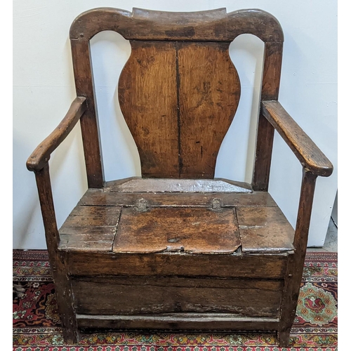 252 - An early 18th century Welsh oak armchair having a curved top rail, vase splat back and the seat with... 