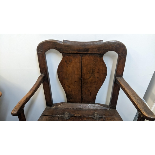 252 - An early 18th century Welsh oak armchair having a curved top rail, vase splat back and the seat with... 