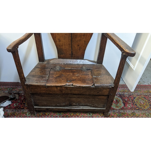 252 - An early 18th century Welsh oak armchair having a curved top rail, vase splat back and the seat with... 