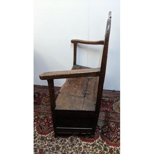 252 - An early 18th century Welsh oak armchair having a curved top rail, vase splat back and the seat with... 