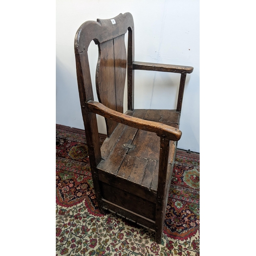 252 - An early 18th century Welsh oak armchair having a curved top rail, vase splat back and the seat with... 