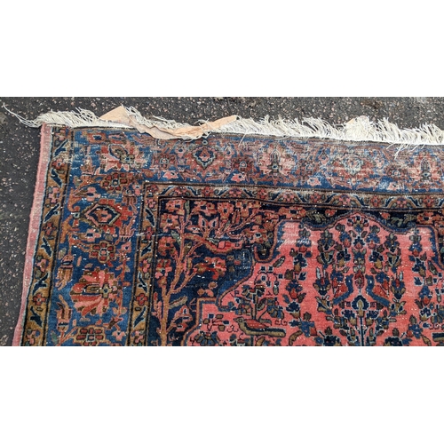 256 - A pair of Persian pictorial hand woven rugs, each on a red ground, the field decorated with an urn, ... 