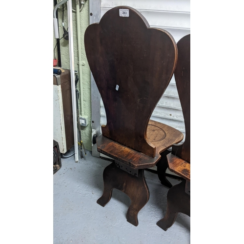 263 - A set of four George II mahogany hall chairs, each of sgabello form with escutcheon shaped backs, ci... 