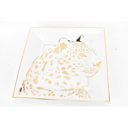 3 - A Cartier porcelain trinket tray, square formed and decorated in gilt with a panther, signed Cartier... 