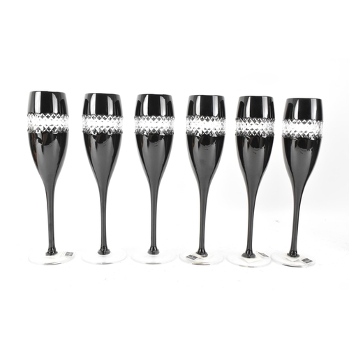 33 - A set of six Waterford black lead crystal cut champagne flutes, designed by John Rocha, each of tape... 