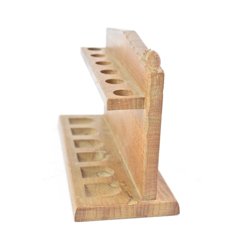 80 - Robert Mouseman Thompson (1876-1955): An English Oak Pipe Rack, with six holders, shaped square back... 