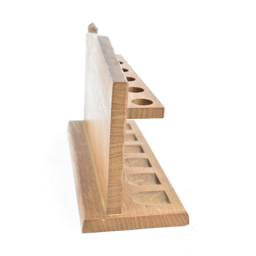 80 - Robert Mouseman Thompson (1876-1955): An English Oak Pipe Rack, with six holders, shaped square back... 